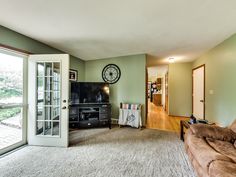 a living room with a couch, television and sliding glass doors