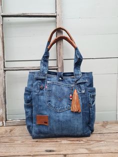 "An everyday shoulder bag with lot of pockets made from a pair of blue classic Levis jeans with details preserved. This listing has been updated again and again, a little different everytime but always made from reused materials. Last pic is of previous levis jeans shoppers, if you dont like the one available at the moment, come back later and maybe youll find your favorite! Made from a pair of Classic blue Levis with worn traces. Leather vintage levis label and leather details for a boho vibe. Classic Levis Jeans, Everyday Shoulder Bag, Reused Materials, Denim Bag Diy, Denim Shoulder Bag, Denim Bags, Denim Purse, Denim Shoulder Bags, Recycled Jeans