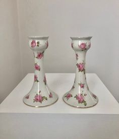 two white vases with pink flowers on them