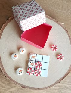 a wooden table topped with white and red items on top of a piece of wood