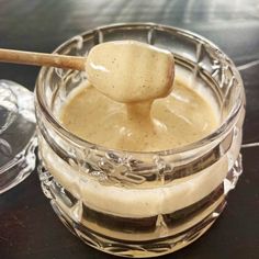 a glass bowl filled with liquid and a wooden spoon sticking out of the top in front of it