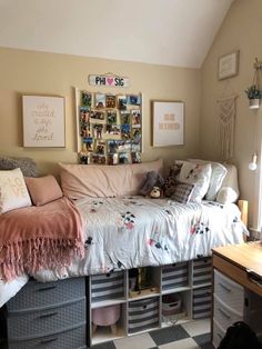 a bed with lots of pillows and blankets on top of it in a room that has a checkered floor