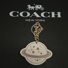 the coach keychain is on display in front of a black background with gold stars