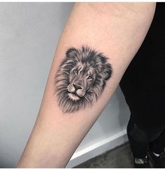 a black and white lion tattoo on the arm