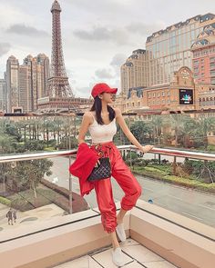 a woman standing on top of a balcony next to the eiffel tower