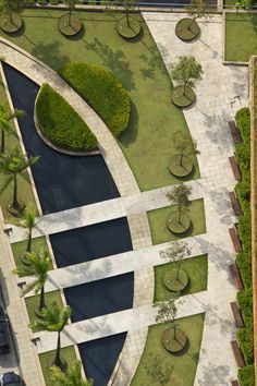 an aerial view of a park with water and trees in the center, surrounded by greenery