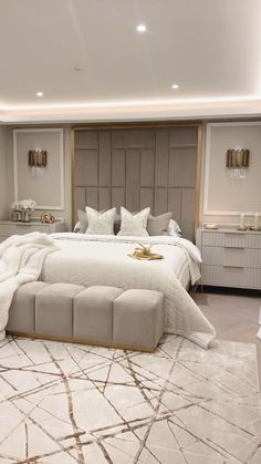 a large bed sitting in the middle of a bedroom next to a white and gold rug