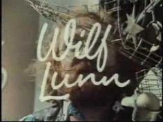 a man with long hair standing in front of a neon sign that reads ugly luna