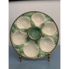 a green and white plate with seashells on it