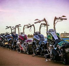 a row of parked motorcycles sitting on the side of a road next to each other