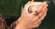 a close up of a person holding a coffee cup with the word love on it