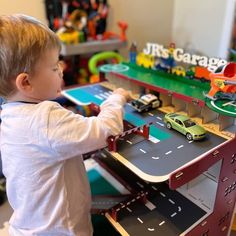 a little boy playing with his toy car set