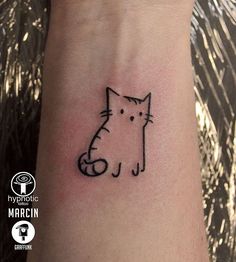 a small cat tattoo on the wrist