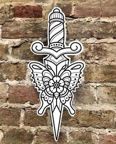 a white and black sticker on a brick wall with a dagger in the middle