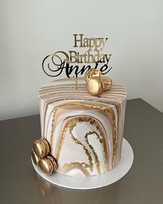 a marble cake with gold decorations on top and a happy birthday sign in the middle