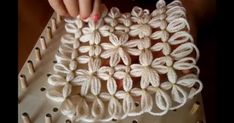 someone is working on an intricate crochet project with white yarn and flowers in the center