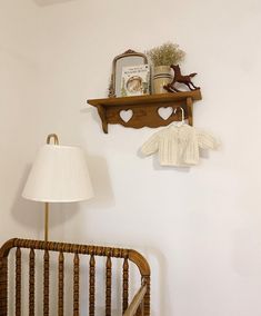 a wooden rocking chair sitting next to a lamp on top of a white wall in a room