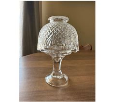 a clear glass vase sitting on top of a wooden table