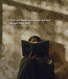 a person reading a book in front of a wall with a quote on it that says, you can't break a person who gets their strength from aliah