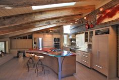 a large kitchen with an island in the middle and two stools next to it