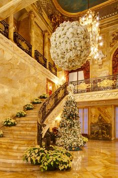 an ornate staircase in a building with christmas decorations on the balconies and chandeliers