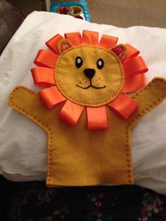 a close up of a pillow with a stuffed animal on it's face and arms in the shape of a lion