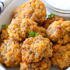 a white bowl filled with meatballs next to a small bowl of ranch dressing on the side