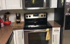 a kitchen with stainless steel appliances and white cabinets