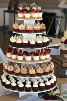 a three tiered cupcake display on a table