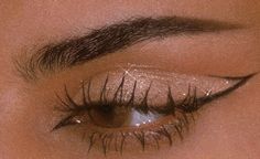 a woman's eye with long lashes and glitters on her eyeshade