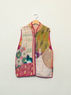 a colorful vest hanging on a white wall