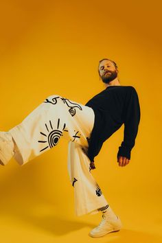 a man in black shirt and white pants doing a kick with his leg on the ground