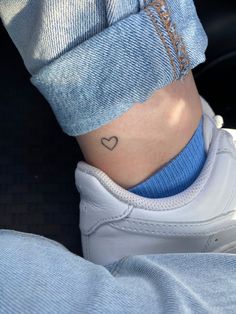 a person with a small heart tattoo on their left side ribcading the ankle