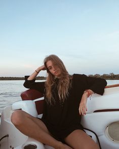 a woman sitting on the back of a boat