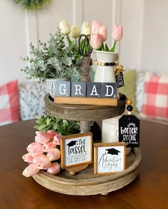 a tiered tray with flowers and graduation signs on it