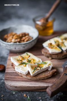 crackers with cream cheese and nuts on a cutting board