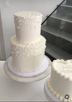 two white wedding cakes sitting next to each other