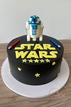 a star wars birthday cake with a robot on top and writing on the side,