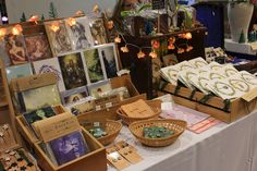 an assortment of cards and other items on display at a table with lights in the background