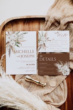 the wedding stationery is laid out on a wooden tray