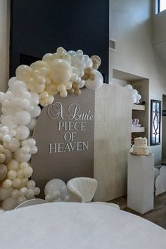 a large balloon arch is decorated with white balloons