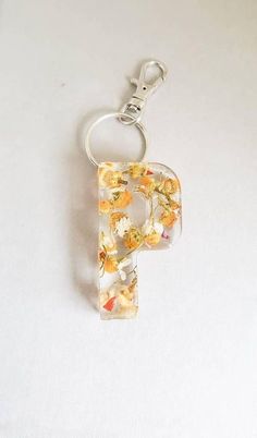 the letter p is made up of flowers and leaves on a clear plastic keychain