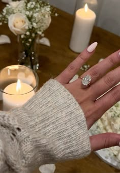 a woman's hand with white manicures and a ring on her finger