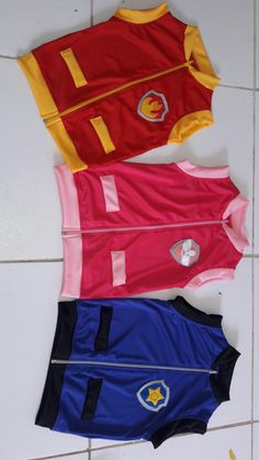 three swimsuits laid out on the floor in different colors