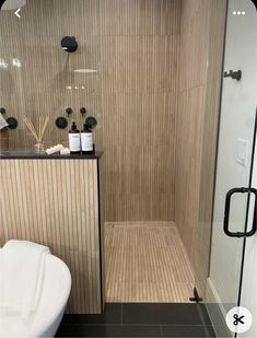 a bathroom with a stand up shower next to a white bath tub and black accents