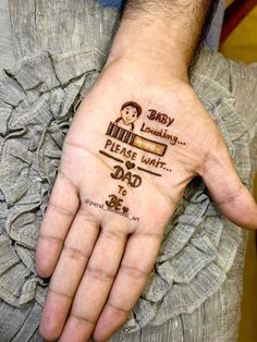 a person's hand with the words baby loading please wait and dad to be written on it