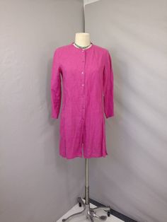 "Soft surface and rich color on this vintage linen tunic shirt jacket. The label is Eileen Fisher, fabric content 100% linen. Photographed un ironed. Natural slightly nubby linen surface, mid weight, color is a wonderful dark magenta pink - not quite as bright/ florescent looking as it photographed. Shape is slim tunic style with a skinny band collar and button front all the way down, deep side slits & long sleeve. Size is marked XS, shown on a 6mannequin, please go by measurements. Machine Spring Linen Blouse With Buttons, Spring Linen Blouse With Placket, Spring Workwear Tunic With Buttons, Long Sleeve Linen Blouse With Button Closure, Long Sleeve Linen Dress With Buttons For Work, Button-up Tunic For Daywear, Long Sleeve Tunic With Buttons For Daywear, Spring Linen Tunic With Buttons, Spring Button-up Tunic With Buttons