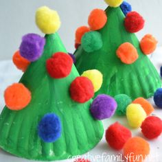 paper plate christmas trees with pom - poms on the top and one is green