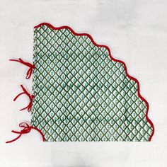 a piece of cloth with red thread on it and a green pattern in the middle