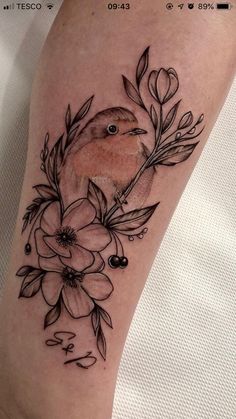 a bird sitting on top of a flower tattoo